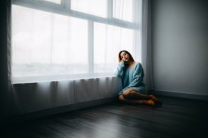 woman with poor mental health sitting on the floor
